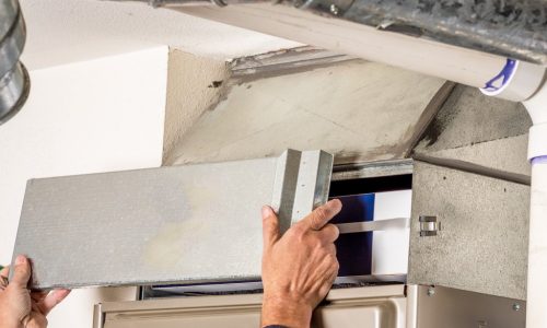 Technician removing furnace access panel